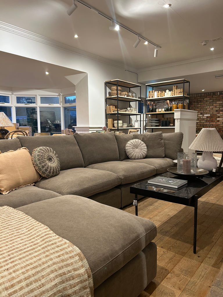 Modern living room with a grey corner sofa and decorative pillows.